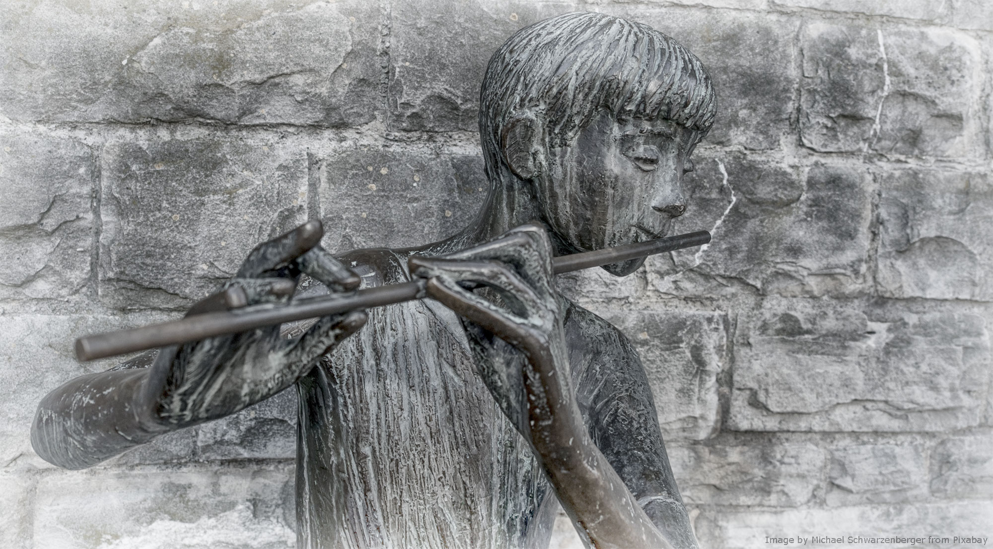 A boy playing flute, bronze statue